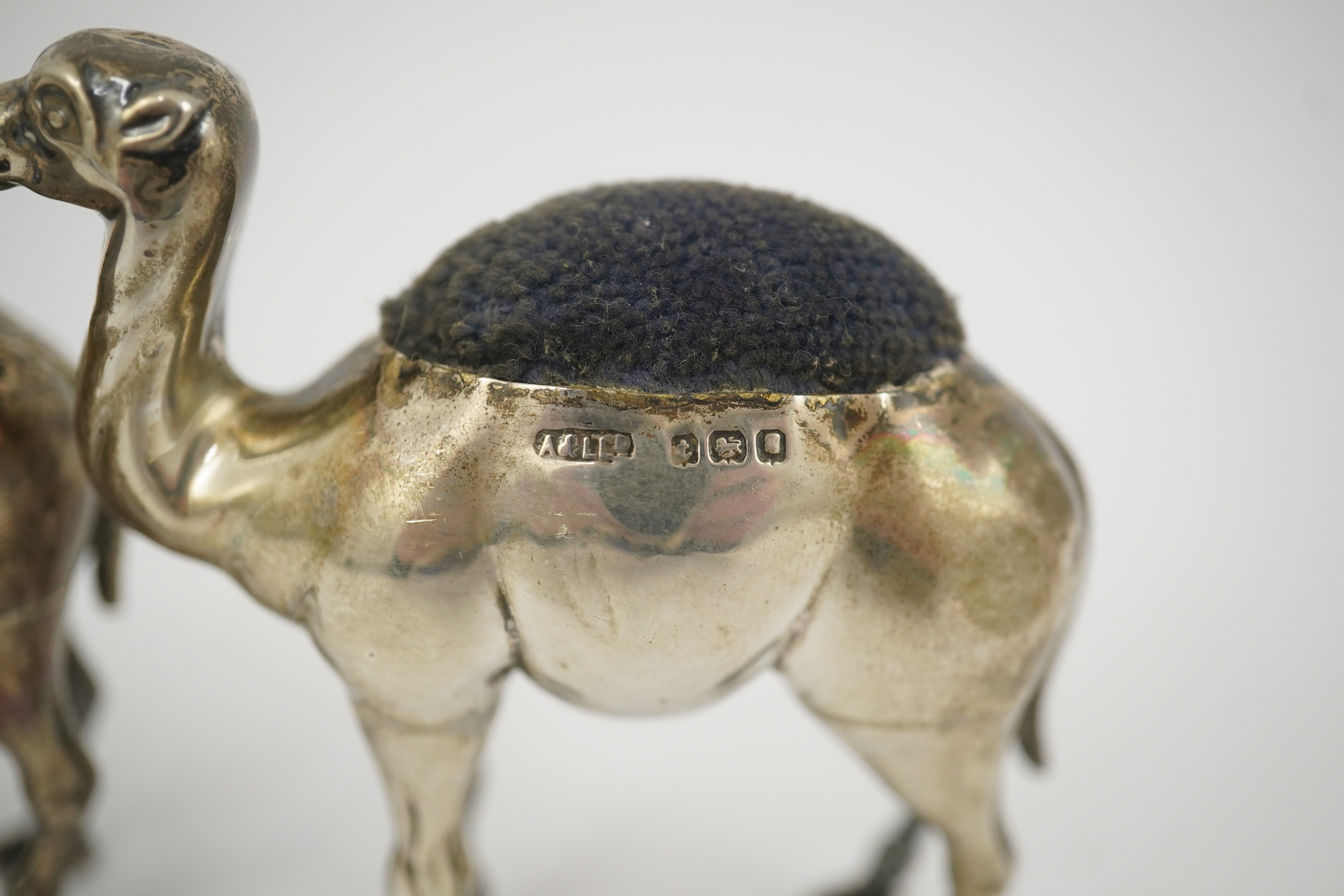 A pair of Edwardian novelty silver pin cushions, each modelled as a camel